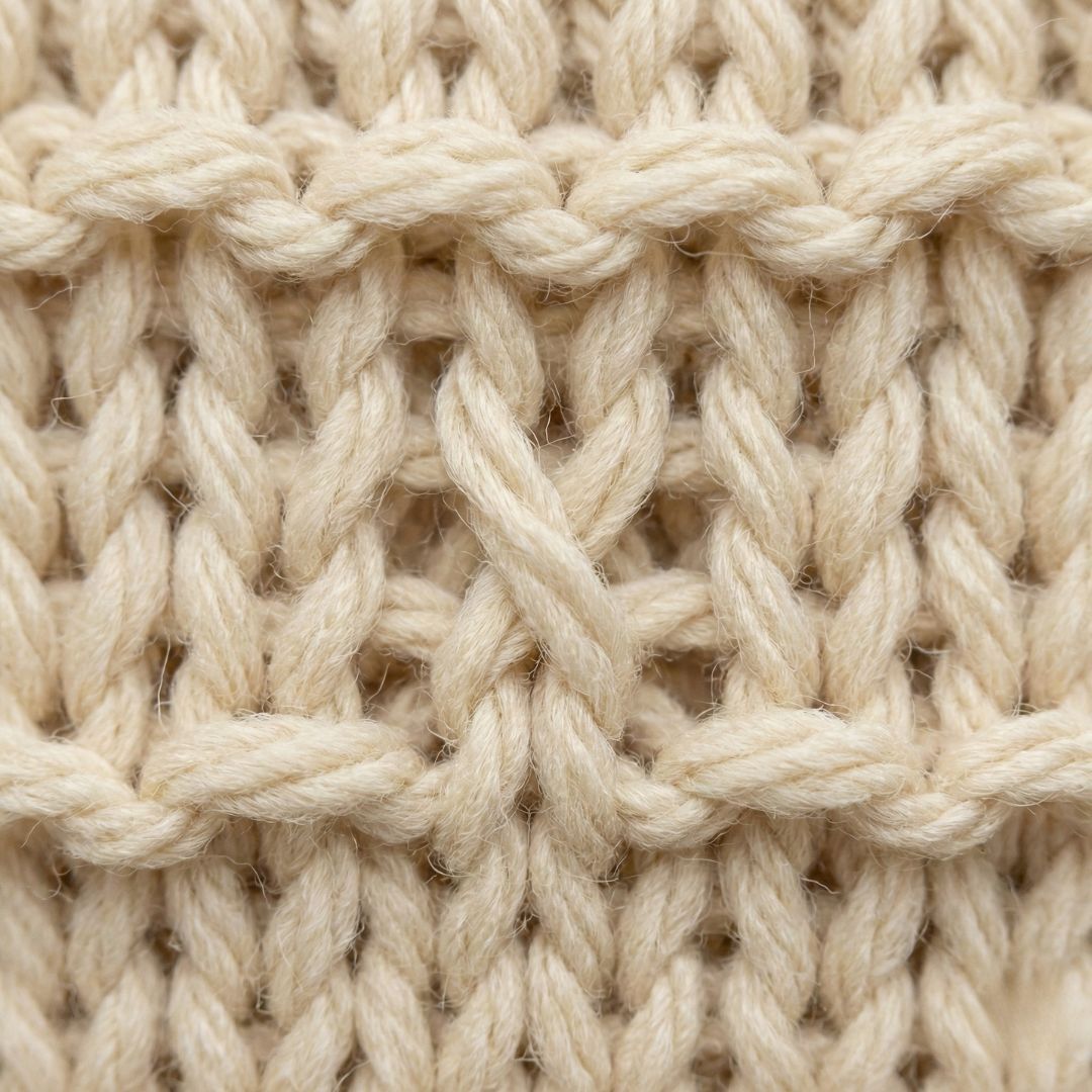 lose-up of a twisted knitting stitch compared to correct stitches to help makers identify mistakes early.