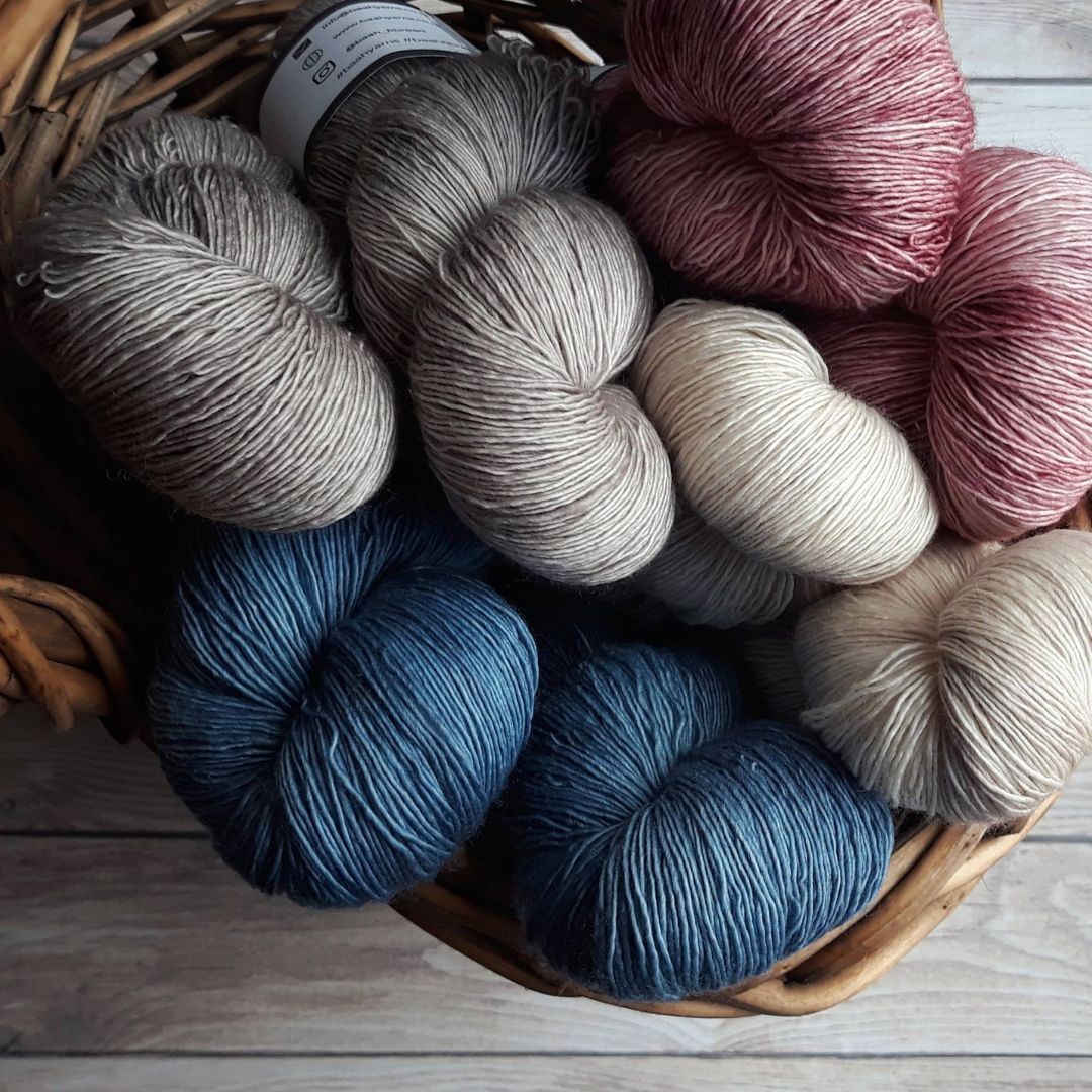 Several hanks of DK weight yarn in a basket
