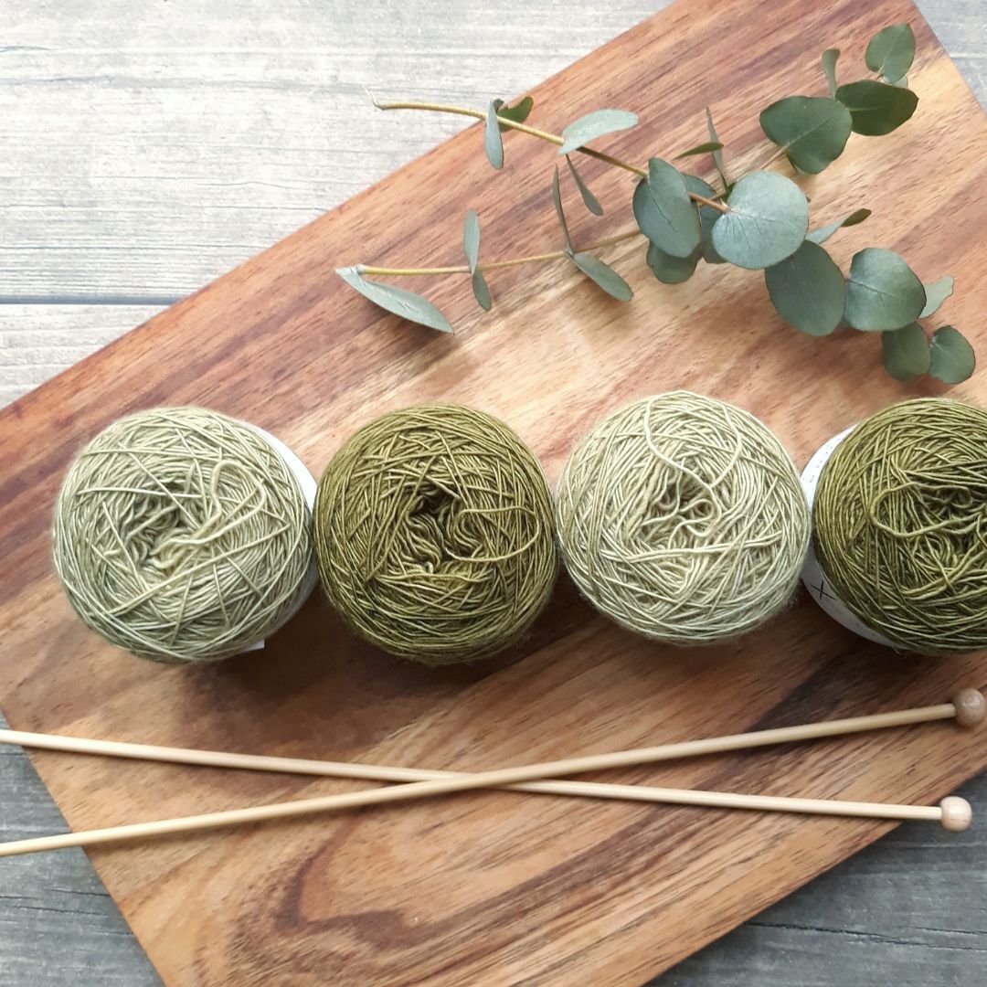 Four cakes of DK weight yarn and knitting needles